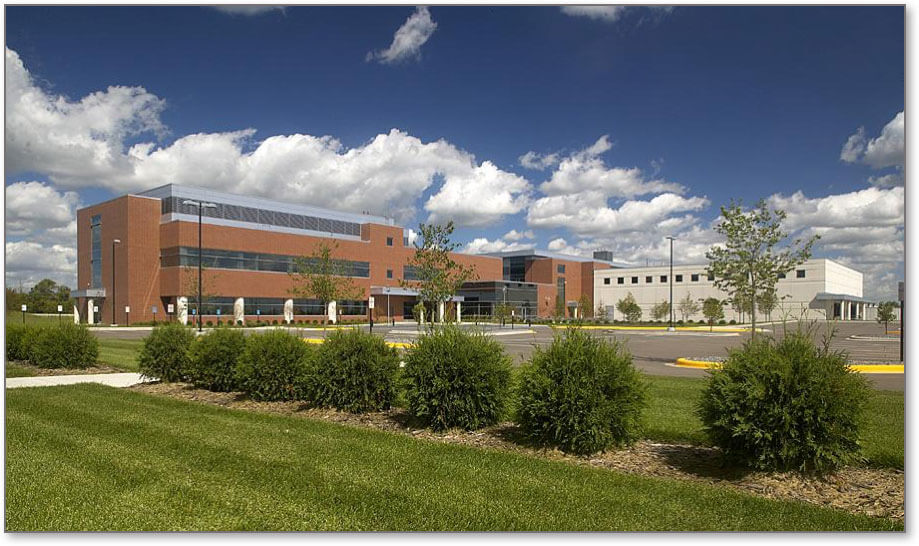 The Baxalta Brooklyn Park facility, a brick and glass building with landscaped grounds