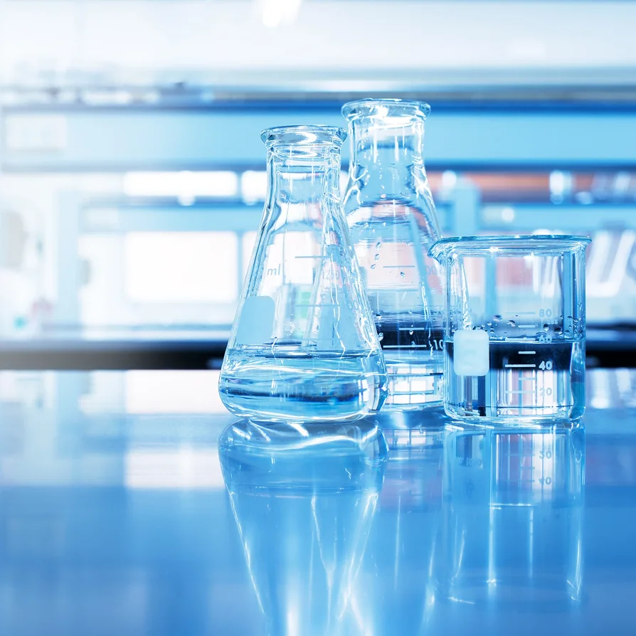Erlenmeyer flasks and a beaker on a laboratory bench